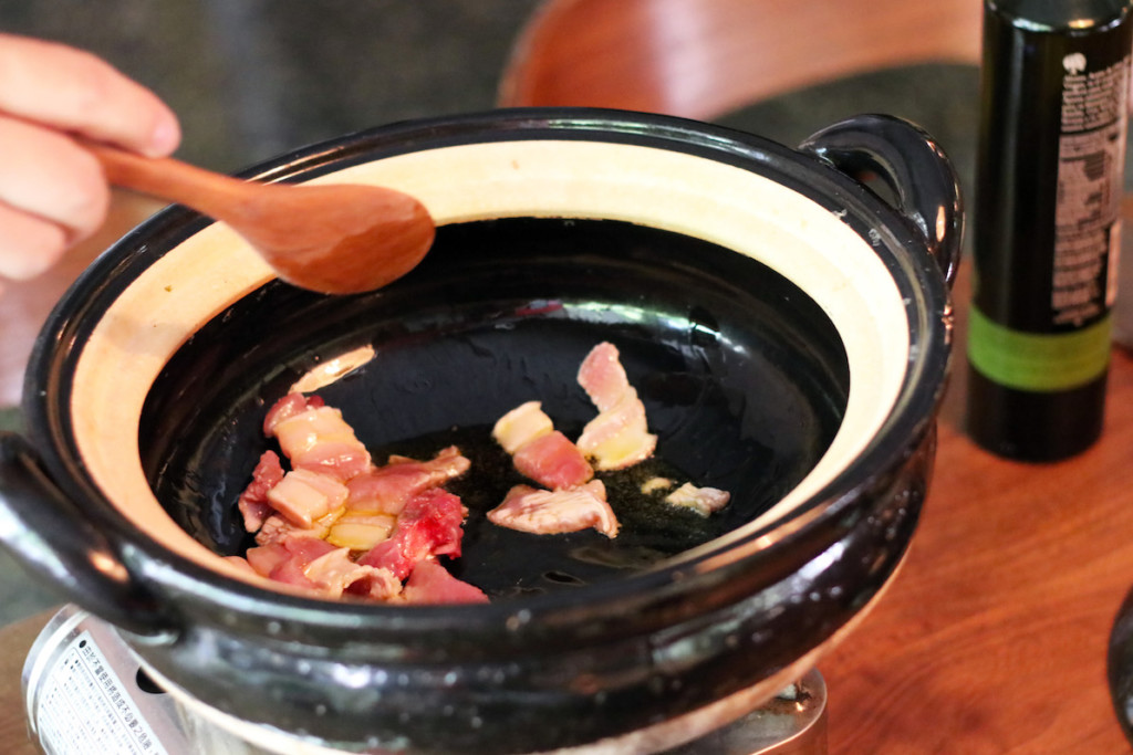 土鍋で豚バラ肉を炒めているようす