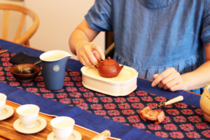 茶芸師が台湾茶を器に注ぐ準備をしている様子